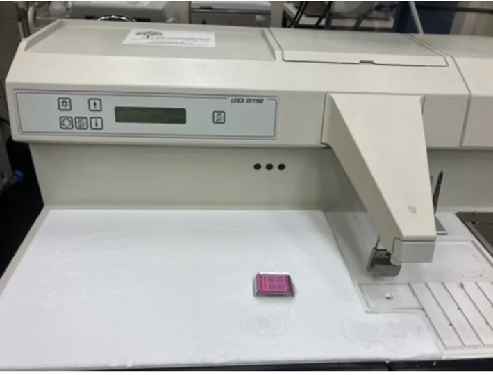 Paraffin embedding equipment with a small pink cassette on its work surface