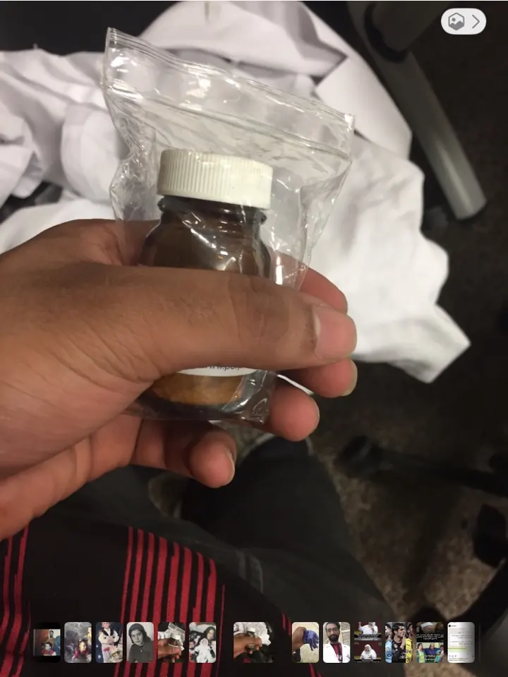 A small amber glass laboratory bottle sealed inside a clear bag, held at Qatar University in July 2017