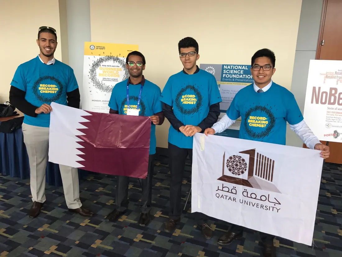 Delegation photograph with Qatar University and Qatar flags near the Guinness World Records attempt signage. Participation in an attempt is not evidence of a record being awarded.